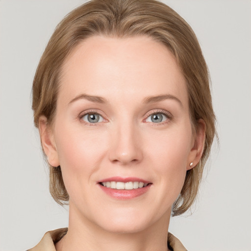 Joyful white young-adult female with medium  brown hair and blue eyes