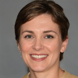 Joyful white young-adult female with medium  brown hair and grey eyes