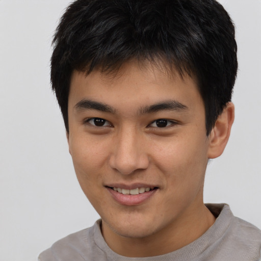 Joyful asian young-adult male with short  brown hair and brown eyes