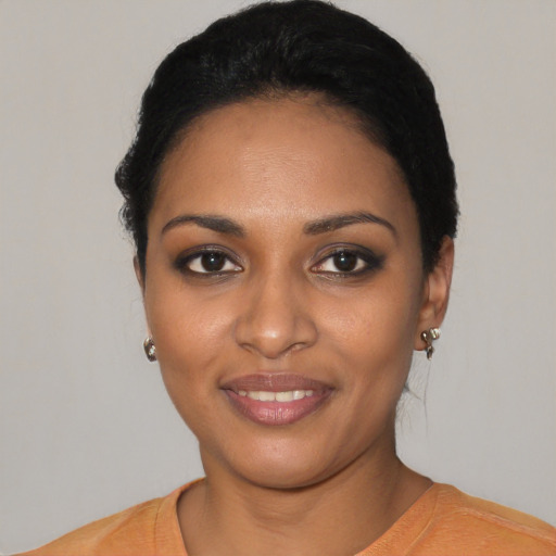 Joyful black young-adult female with short  black hair and brown eyes