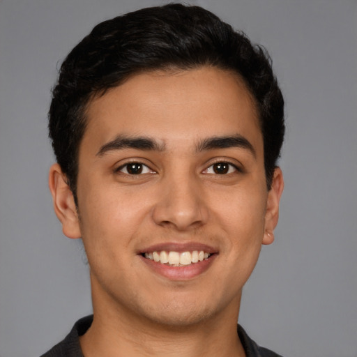 Joyful latino young-adult male with short  brown hair and brown eyes