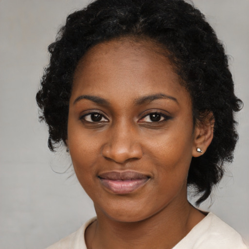 Joyful black young-adult female with medium  black hair and brown eyes