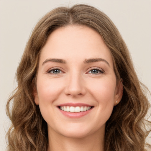 Joyful white young-adult female with long  brown hair and green eyes