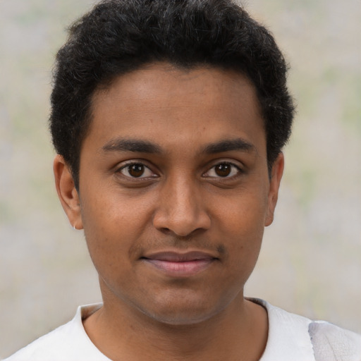 Joyful black young-adult male with short  brown hair and brown eyes