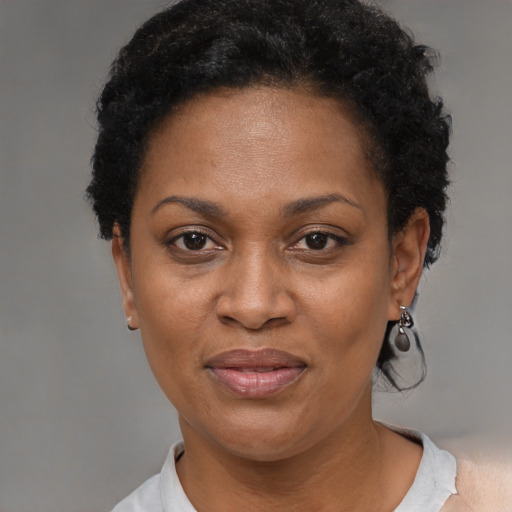 Joyful black adult female with short  black hair and brown eyes