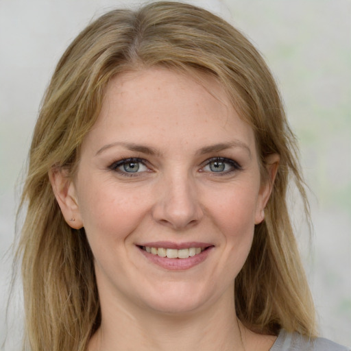 Joyful white young-adult female with medium  brown hair and green eyes