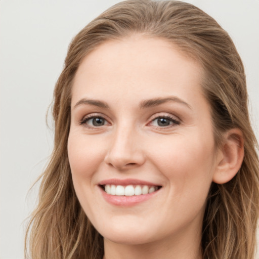 Joyful white young-adult female with long  brown hair and blue eyes