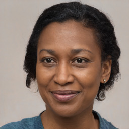 Joyful black adult female with medium  brown hair and brown eyes