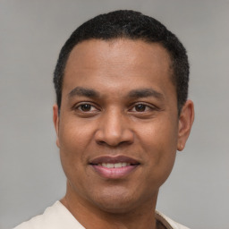 Joyful latino young-adult male with short  black hair and brown eyes