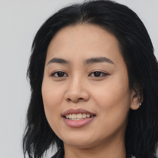 Joyful asian young-adult female with long  black hair and brown eyes