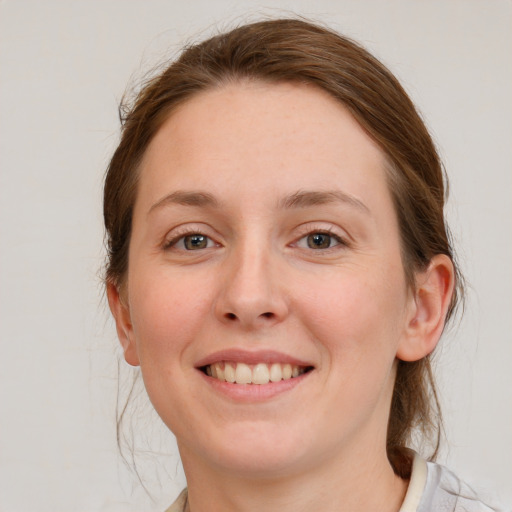 Joyful white young-adult female with medium  brown hair and grey eyes