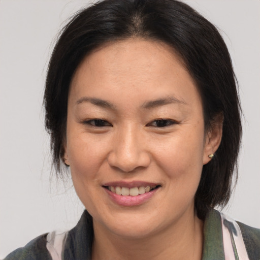 Joyful asian adult female with medium  brown hair and brown eyes