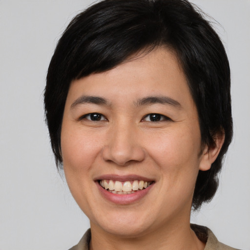 Joyful asian young-adult female with medium  brown hair and brown eyes