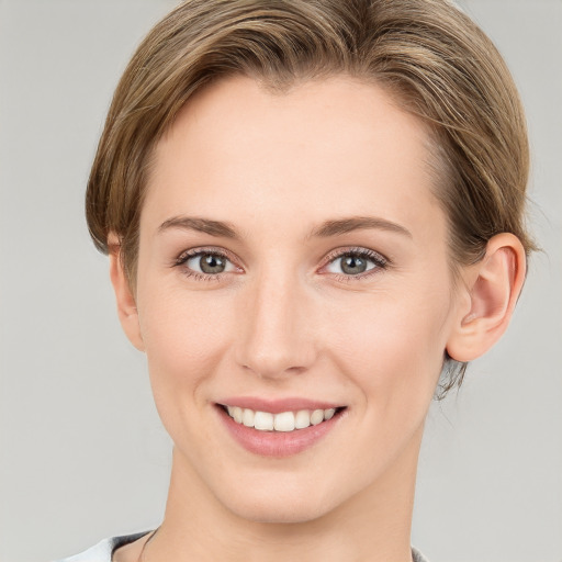 Joyful white young-adult female with short  brown hair and grey eyes