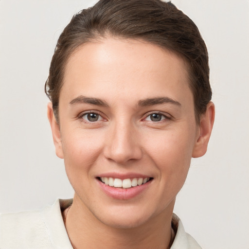 Joyful white young-adult female with short  brown hair and brown eyes