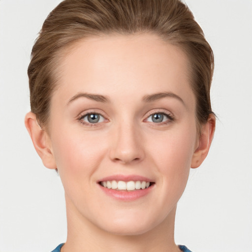 Joyful white young-adult female with short  brown hair and blue eyes