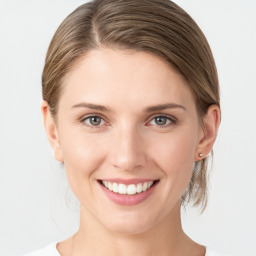 Joyful white young-adult female with medium  brown hair and grey eyes