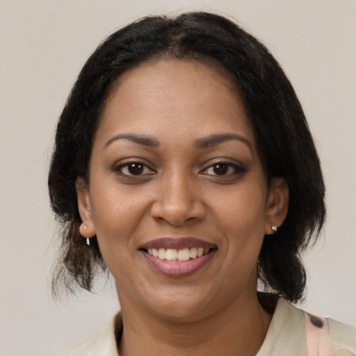 Joyful latino adult female with medium  brown hair and brown eyes
