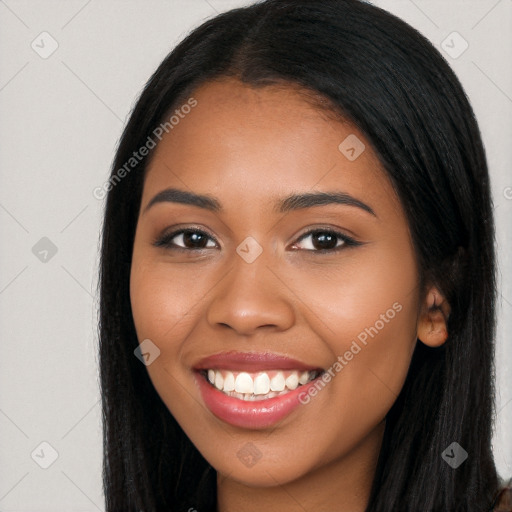 Joyful black young-adult female with long  black hair and brown eyes