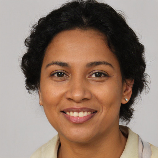 Joyful latino adult female with short  brown hair and brown eyes