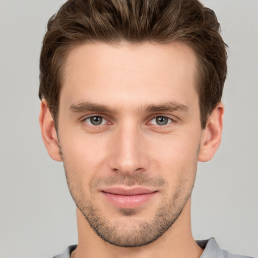 Joyful white young-adult male with short  brown hair and grey eyes