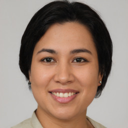 Joyful latino young-adult female with medium  brown hair and brown eyes