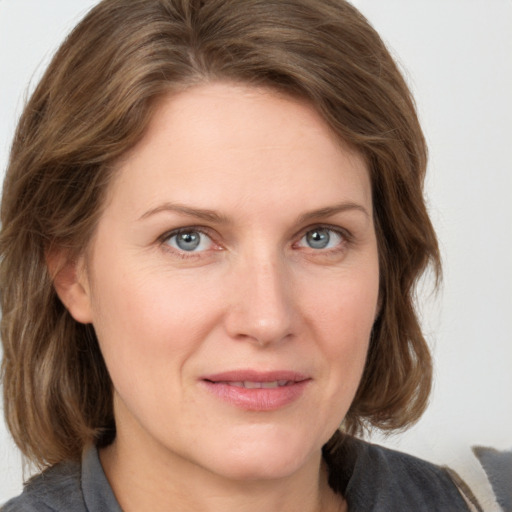 Joyful white adult female with medium  brown hair and grey eyes