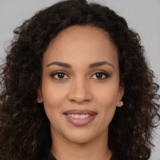 Joyful latino young-adult female with long  brown hair and brown eyes