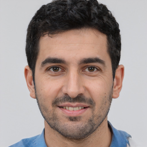 Joyful white young-adult male with short  black hair and brown eyes