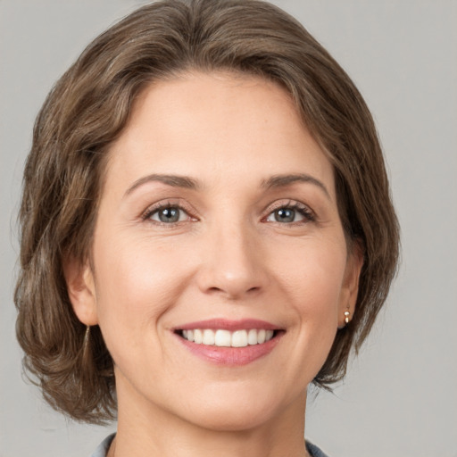 Joyful white young-adult female with medium  brown hair and green eyes