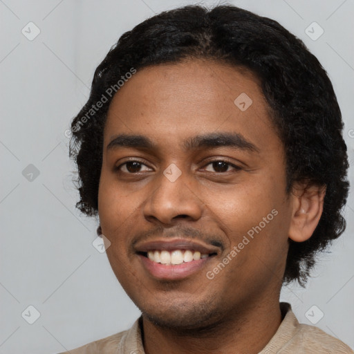 Joyful black young-adult male with short  black hair and brown eyes