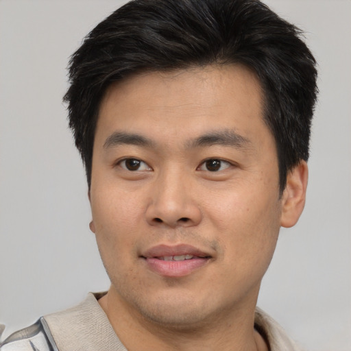 Joyful asian young-adult male with short  brown hair and brown eyes