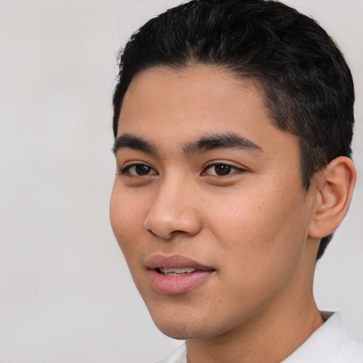 Joyful latino young-adult male with short  black hair and brown eyes