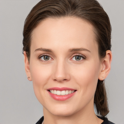 Joyful white young-adult female with medium  brown hair and grey eyes