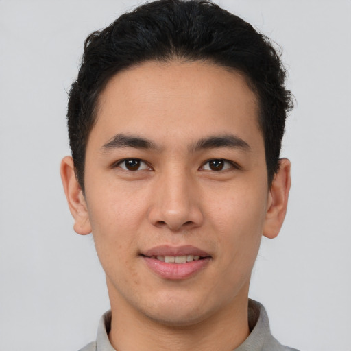 Joyful latino young-adult male with short  brown hair and brown eyes