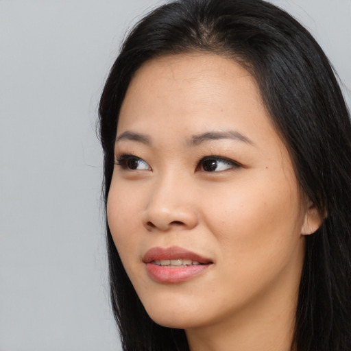 Joyful asian young-adult female with long  black hair and brown eyes