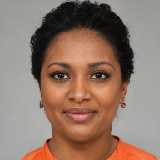 Joyful black young-adult female with short  black hair and brown eyes