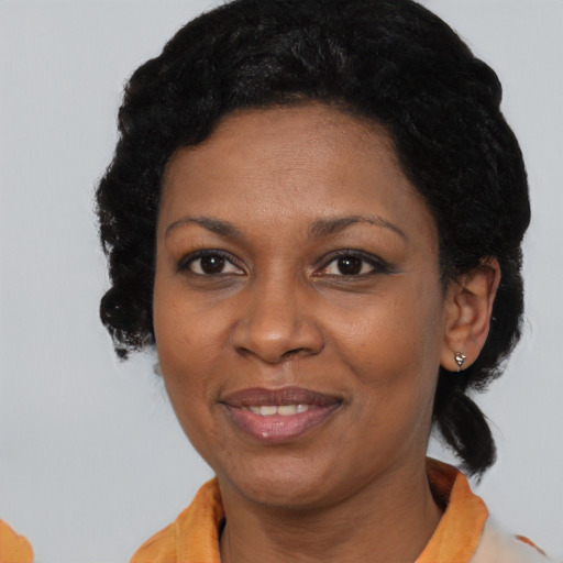 Joyful black adult female with short  black hair and brown eyes