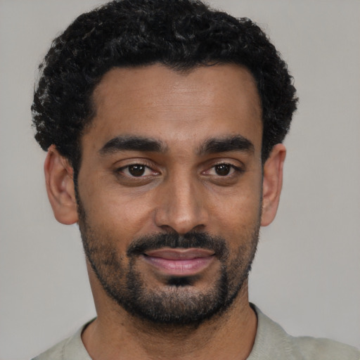 Joyful black young-adult male with short  black hair and brown eyes