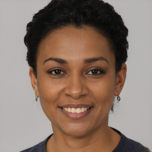 Joyful black young-adult female with short  black hair and brown eyes