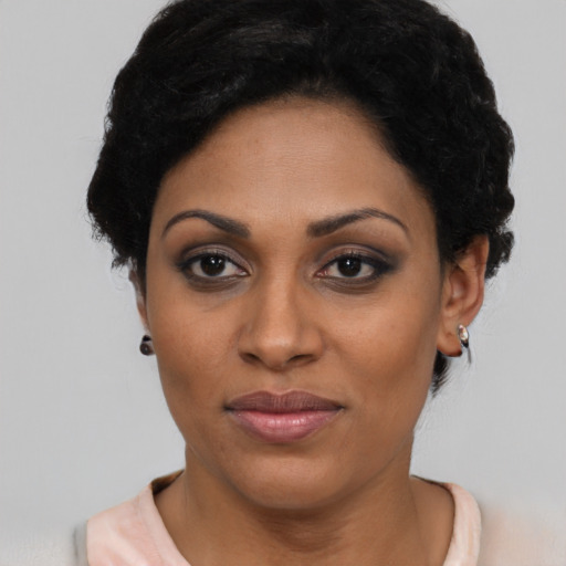 Joyful latino young-adult female with short  black hair and brown eyes