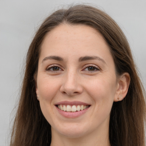 Joyful white young-adult female with long  brown hair and grey eyes