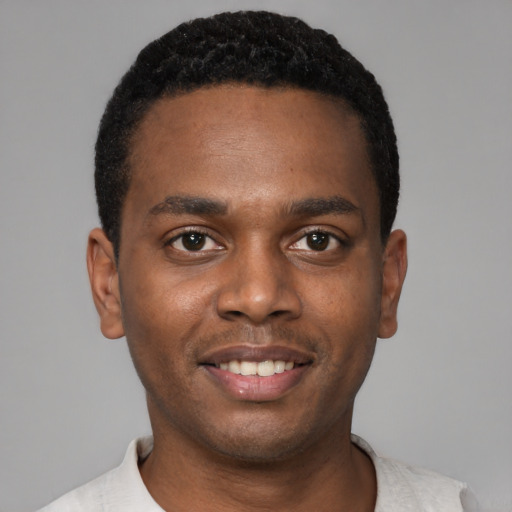 Joyful black young-adult male with short  black hair and brown eyes