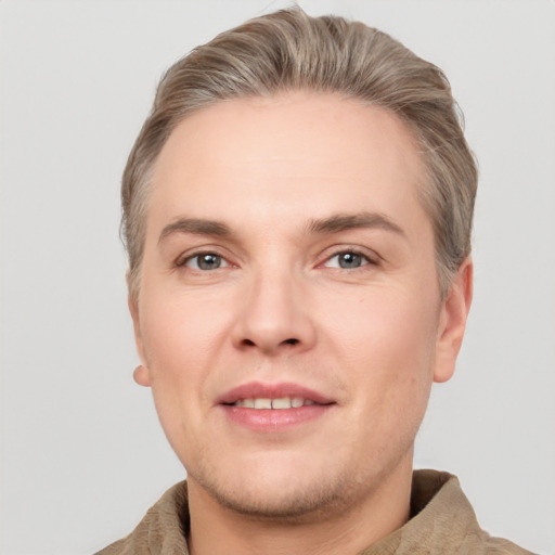 Joyful white young-adult male with short  brown hair and grey eyes