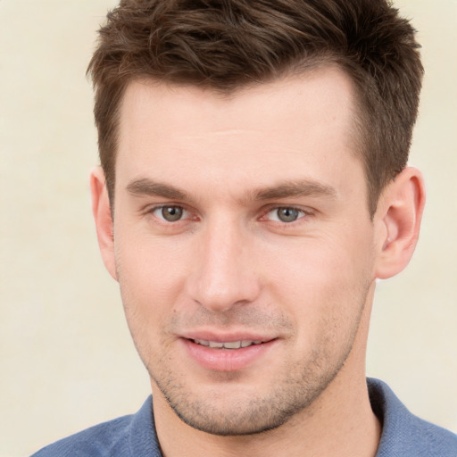 Joyful white young-adult male with short  brown hair and grey eyes