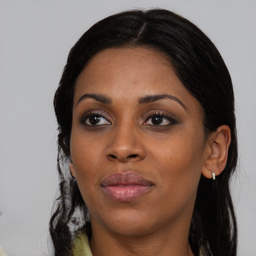Joyful black young-adult female with long  black hair and brown eyes