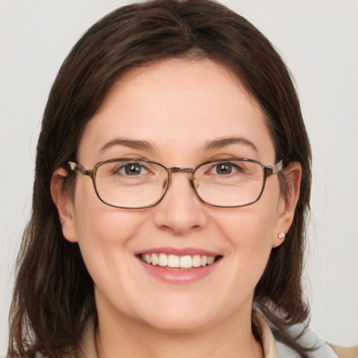 Joyful white adult female with medium  brown hair and blue eyes