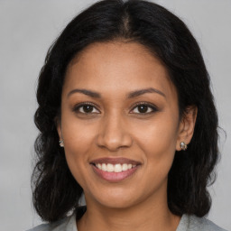 Joyful black young-adult female with long  brown hair and brown eyes