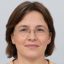 Joyful white adult female with medium  brown hair and grey eyes