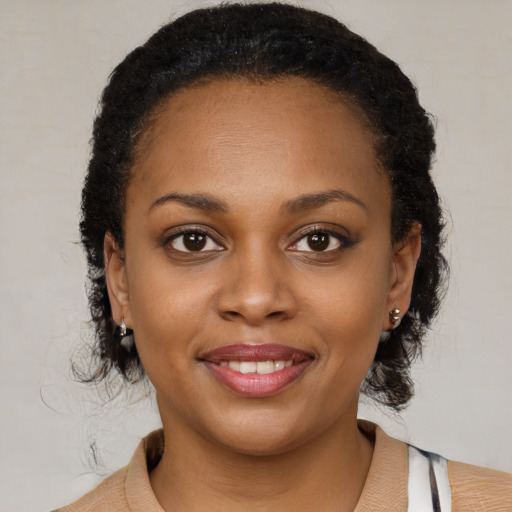 Joyful black young-adult female with medium  black hair and brown eyes